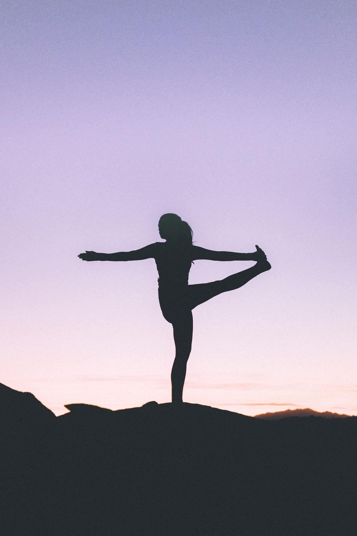 silhouette of woman doing yoga